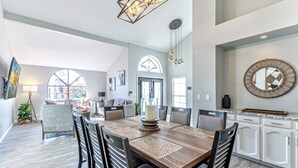 A spacious dining area with a large wooden table, multiple chairs, and a modern chandelier. - Nintendo Super Mario Bros Castle in Scottsdale  (Scottsdale)
