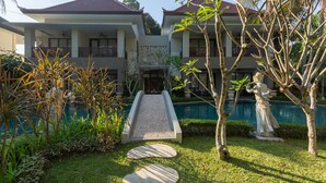 A hotel with a central courtyard, a swimming pool, and a statue. - THE GANTARI UBUD HOTEL & VILLA (Ubud)