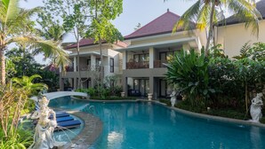 A resort with a swimming pool, a statue, and a two-story building with balconies. - THE GANTARI UBUD HOTEL & VILLA (Ubud)