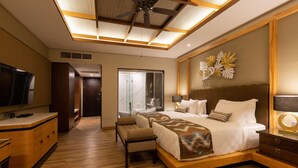 A modern hotel room with a large bed, a desk, a television, and a ceiling fan. - THE GANTARI UBUD HOTEL & VILLA (Ubud)