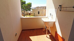Casa de banho pequena com uma pia e janela com vista para um pátio.