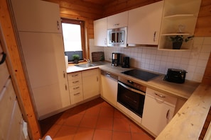 Kitchen equipped with microwave, coffee maker, and toaster, along with a sink and storage cabinets.