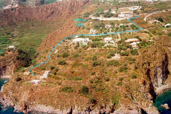 A coastal area with a winding path marked 'Walking Path' leading through a hilly landscape with scattered buildings.