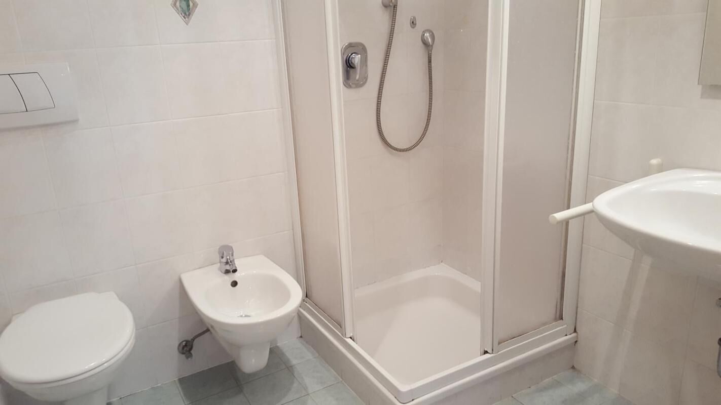 Une salle de bain comprenant des toilettes, un bidet et un espace douche.