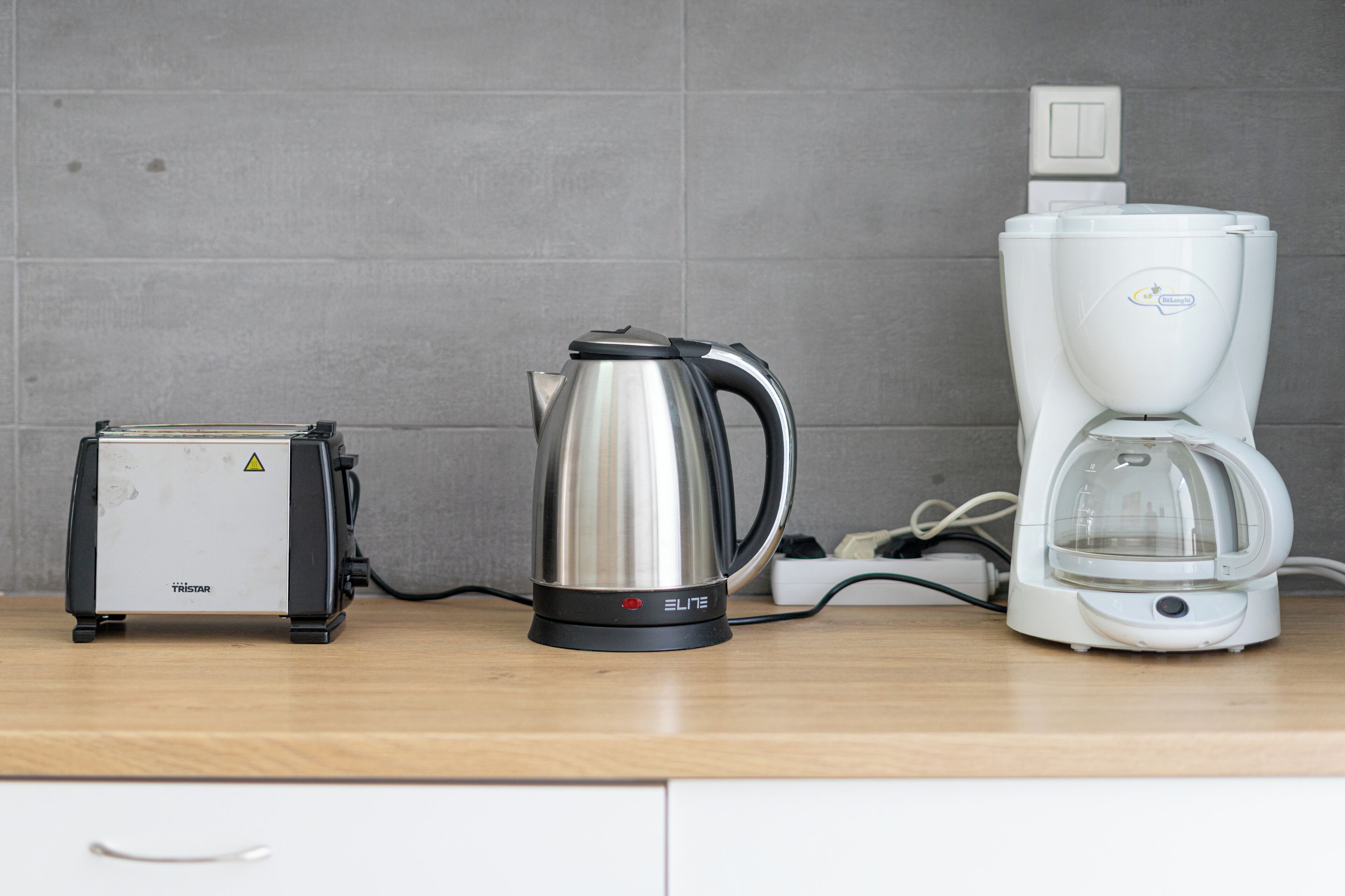 Un plan de travail de cuisine avec un grille-pain, une bouilloire et une machine à café.
