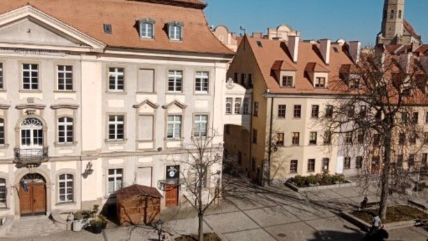 A historic building with a central courtyard, featuring a traditional European architectural style with symmetrical facades and a prominent tower. - Apartment in the Center - na Ratuszu (Jelenia Gora)