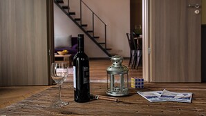 A wooden table with a wine bottle, a glass, a cigar, a lantern, and a Rubik's cube. - New - Walnuttree Double 12 Person Apartment Central in Budapest - Hungary (Budapest)