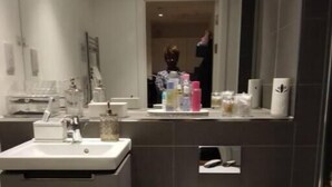 Un bagno moderno con il water, il lavandino e uno specchio.