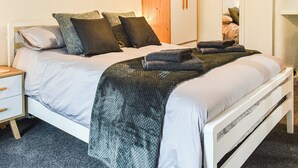 A neatly made bed with a white headboard, a wooden wardrobe, and a small bedside table with a drawer. - 1 bedroom accommodation in Windermere and Troutbeck Bridge (Windermere and Troutbeck Bridge)