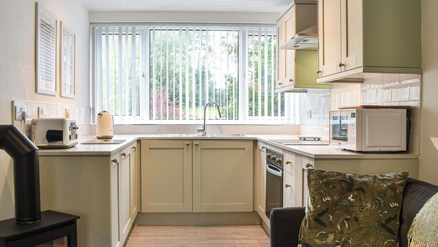 A compact kitchen with a built-in stove, a microwave, and a sink. - 1 bedroom accommodation in Windermere and Troutbeck Bridge (Windermere and Troutbeck Bridge)