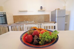 Eine Küche mit einer Obstschale auf dem Tisch.