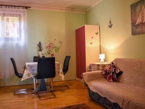 Relax in this inviting space with a dining area for two, a comfortable sofa, and a cozy reading nook.