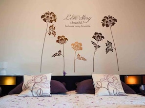 Experience a romantic ambiance in this beautifully decorated bedroom with a stunning floral wall and plush bed.