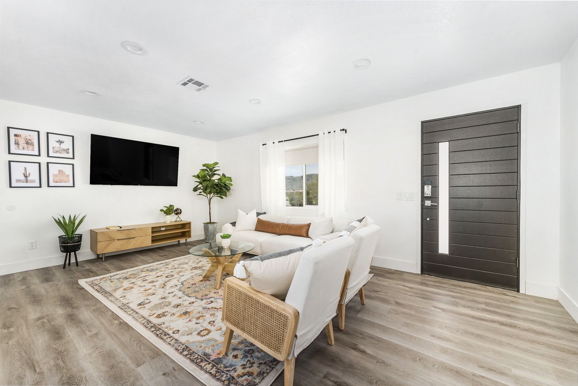 A modern living room with a sofa, coffee table, and a TV mounted on the wall.