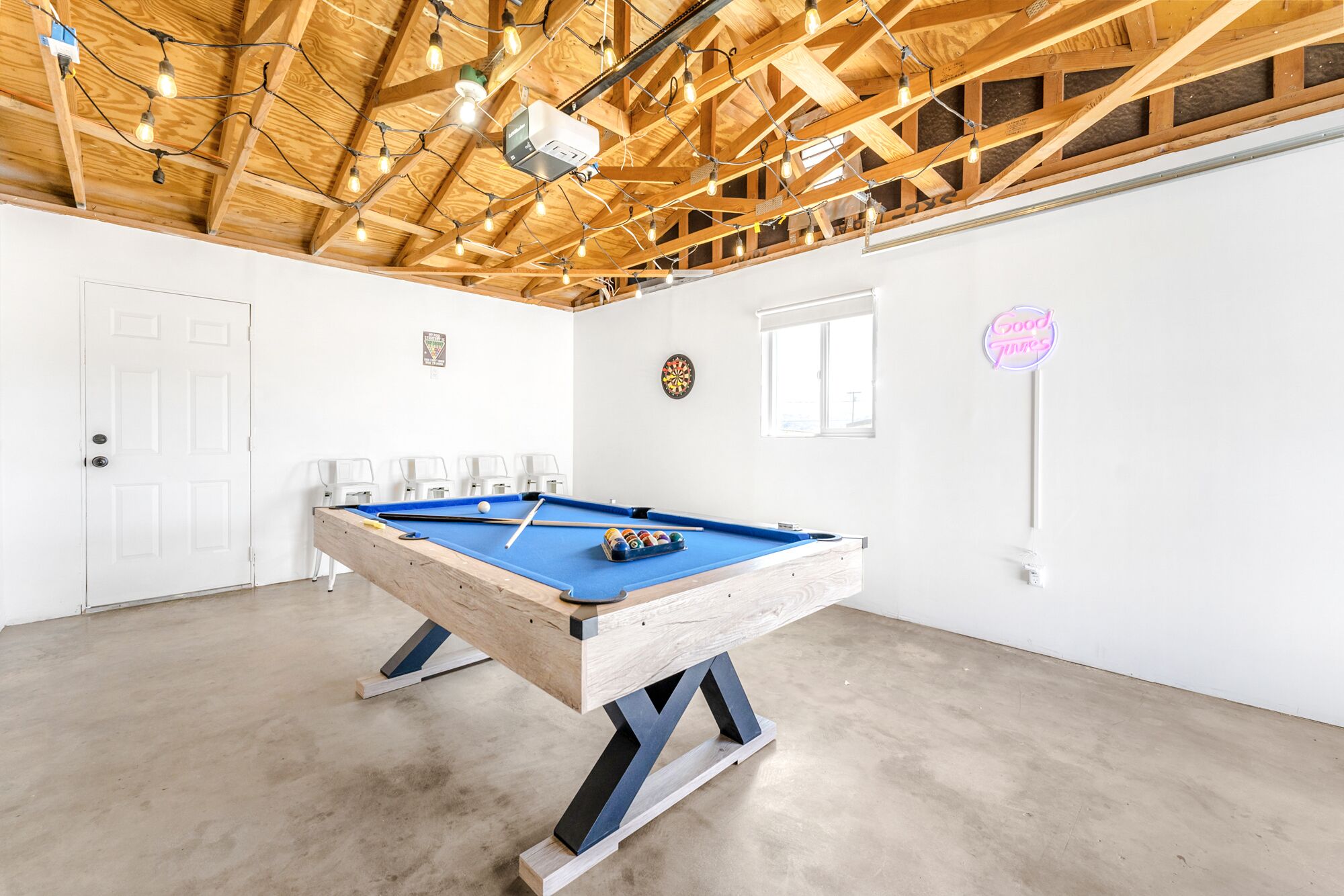 Una mesa de billar en una habitación con techo de madera y paredes blancas.