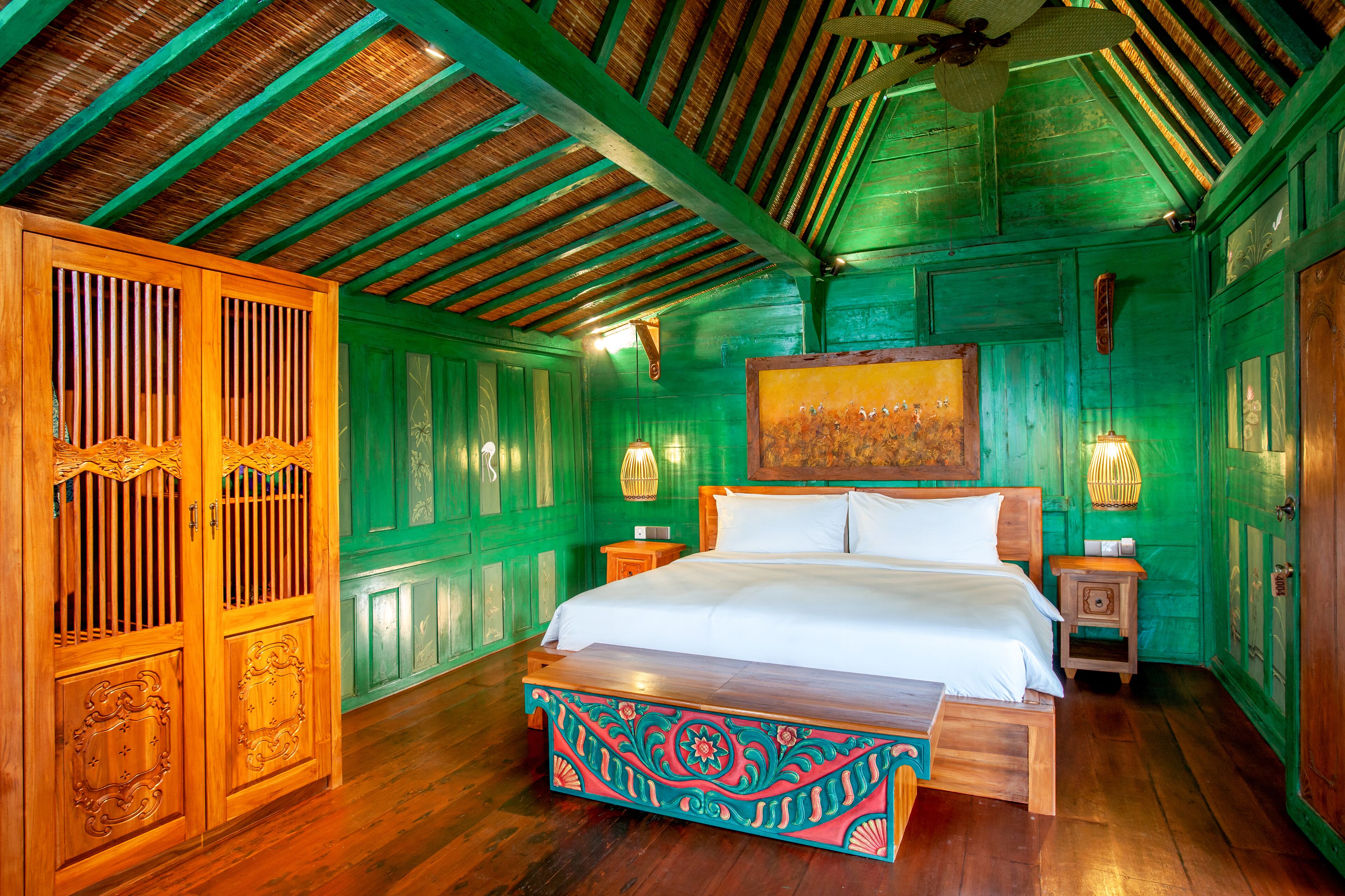 A room with a wooden bed, green walls, and a wooden ceiling.