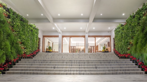 Una imponente escalera conduce a un vestíbulo con techo alto e iluminación empotrada.