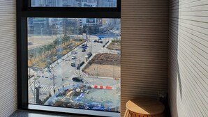 A modern room with a large window overlooking a cityscape and a construction site.