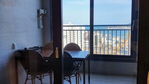 A room with a balcony, a table, and two chairs.