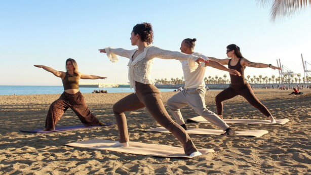 A beach with people practicing yoga. - Coeo Pod Hostel Beatas (Málaga)