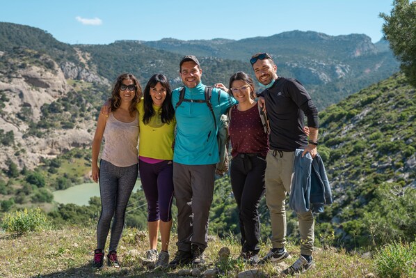 A group of people standing on a grassy hill with a mountainous landscape in the background. - Coeo Pod Hostel Beatas (Málaga)