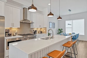 Enjoy cooking in this well-equipped kitchen with a central island, oven, and double sink.