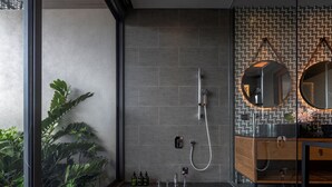 Un bagno moderno con doccia, lavandino e specchio.