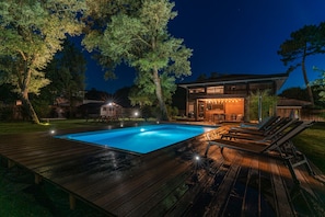 A modern house with a swimming pool, deck, and outdoor seating area at night. - Beautiful Takapuna Villa and Lodge (21 people) (Moliets-et-Maa)