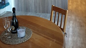 Eine moderne Küche mit Kochinsel, Holzschränken und einem Essbereich mit Tisch für zwei Personen.