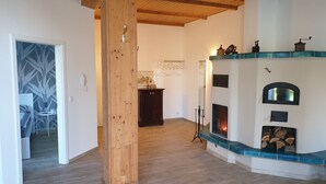 Ein Zimmer mit Holzboden, einem Kamin mit Fliesenverkleidung und einem Holzschrank.