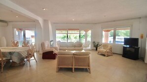 A spacious living room with a dining area, a sofa set, and a television. - The Great Luxury Villa Villa of Atenea (Cautivador)