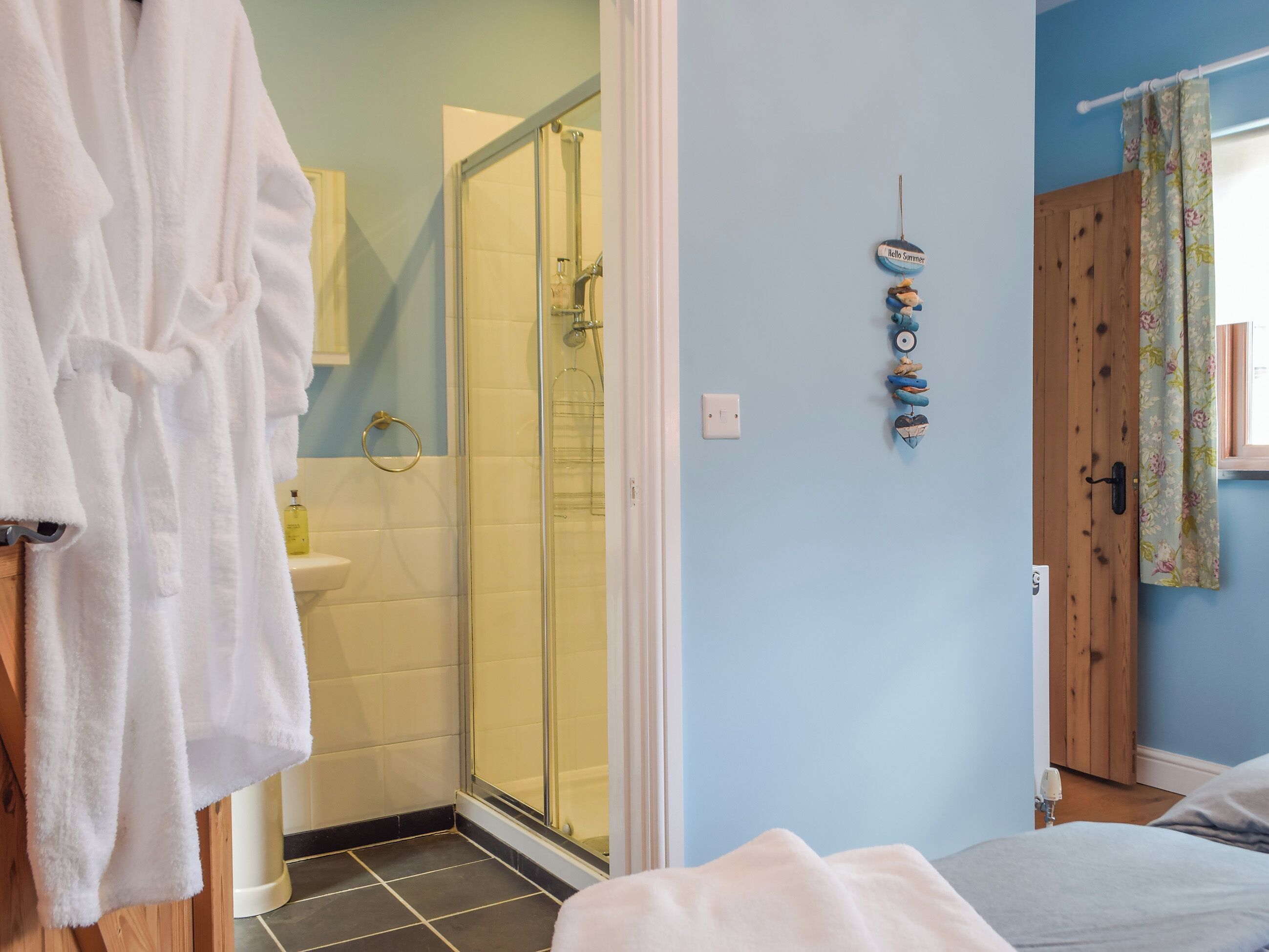 A bathroom with a glass shower, a white bathtub, and a sink.