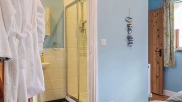 A bathroom with a glass shower, a white bathtub, and a sink.