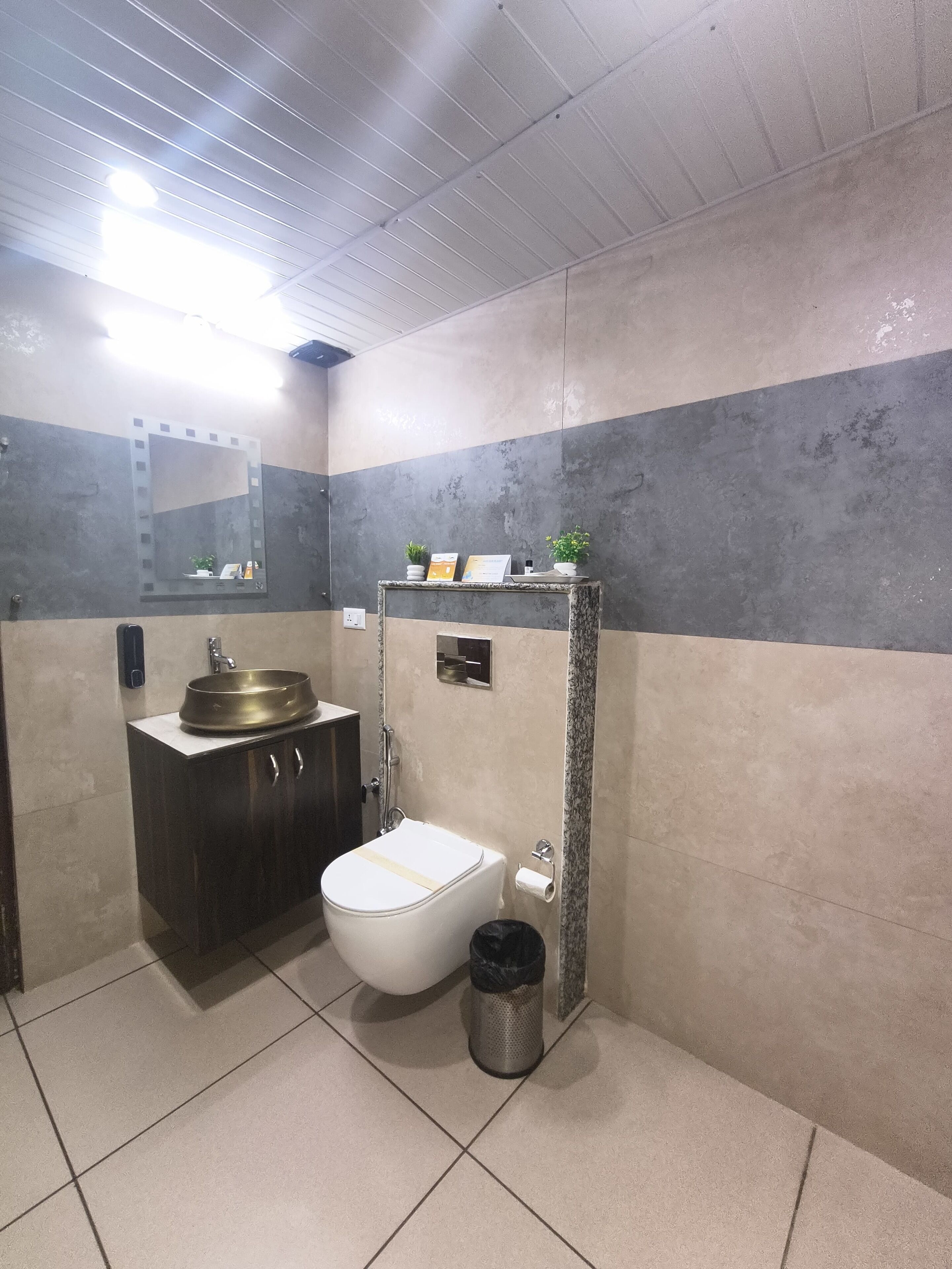 A bathroom with a toilet, sink, and mirror.