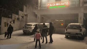 Entrada de un hotel con un letrero que dice "ALIZA INN & SUITES" y "LUJO DEFINIDO".