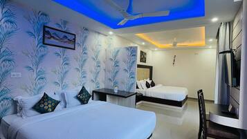 A hotel room with two beds, a desk, and a ceiling fan.