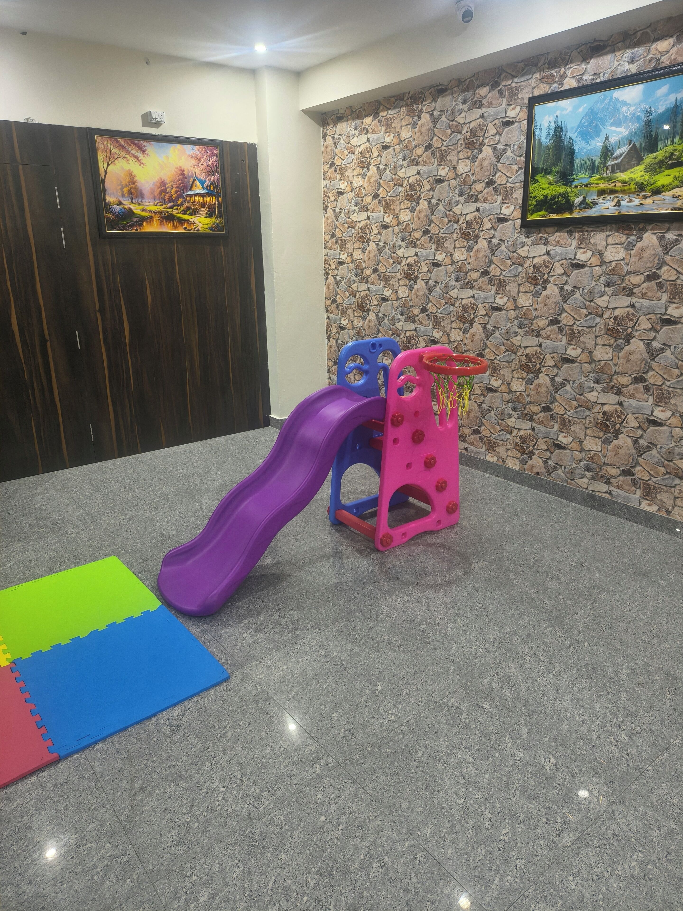 A play area with a purple slide and two small climbing structures.
