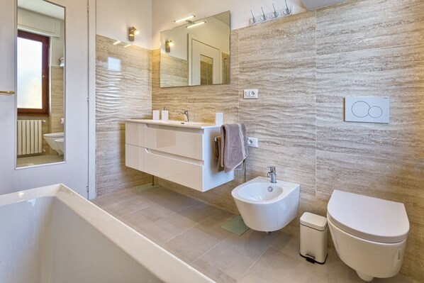 Un baño moderno con bañera, bidé e inodoro.