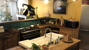 A kitchen with a central island, wooden cabinets, a stove, and a refrigerator.