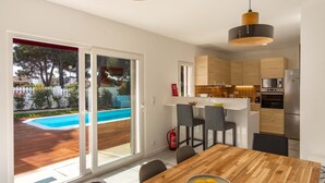 A modern kitchen with wooden cabinets, a built-in oven, and a microwave. - LV Premier LA2 Pool AC Garden sea View  (Sesimbra)