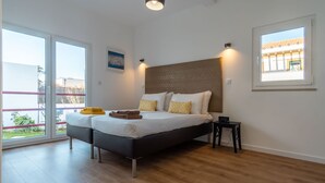A bedroom with a bed, a nightstand, a window, and a view of the outside. - LV Premier LA2 Pool AC Garden sea View  (Sesimbra)