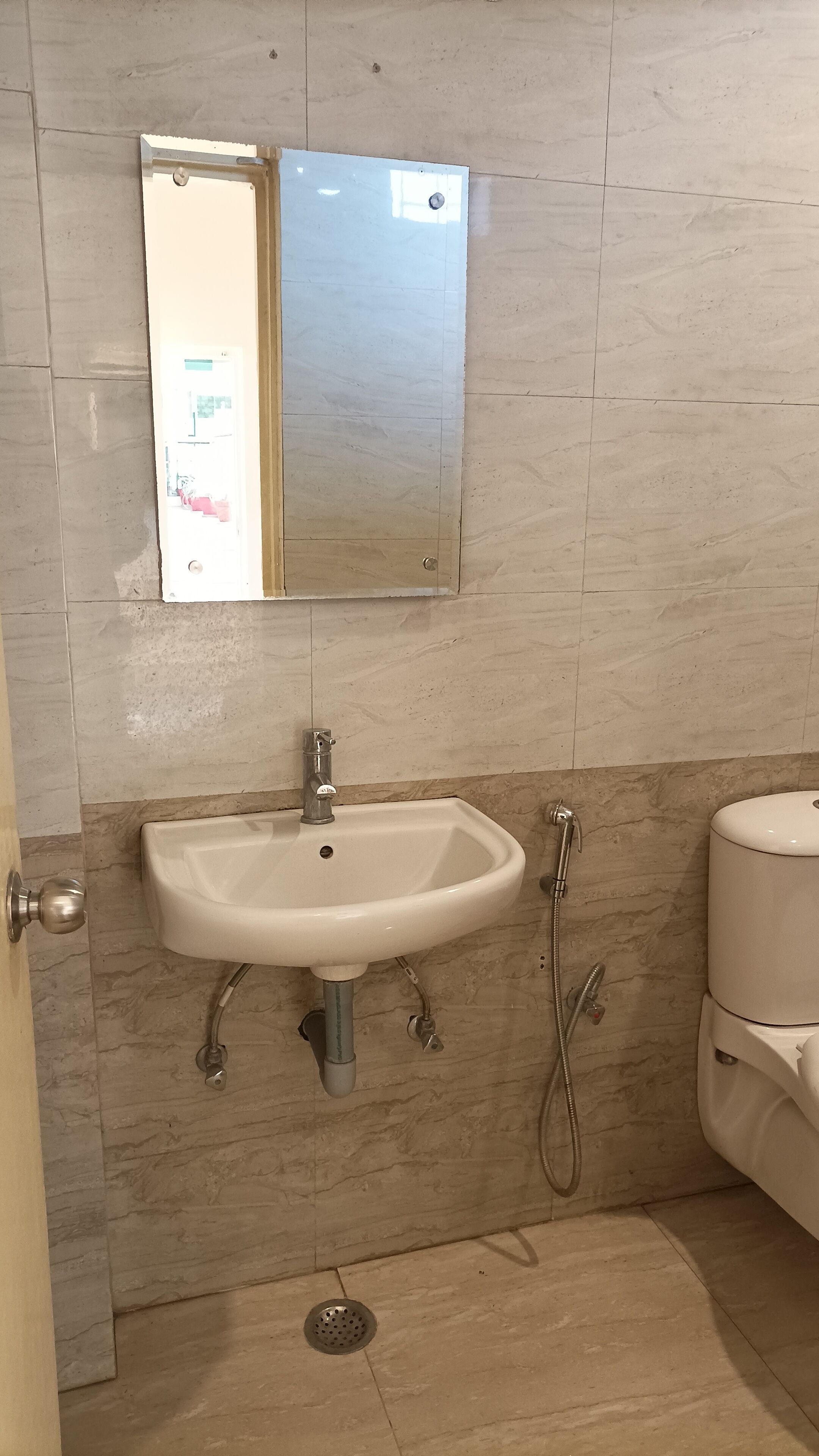 A bathroom with a white sink, a mirror, a toilet, and a shower.