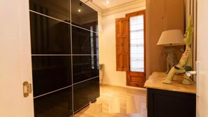 A room with a sliding glass door leading to a balcony, a wooden door, a lamp, and a small statue on a table. - Lovely 2-bed Apartment in Rawalpindi (Rawalpindi)
