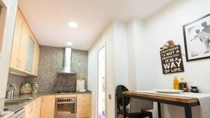 A compact kitchen with wooden cabinets, a stainless steel oven, and a granite backsplash. - Lovely 2-bed Apartment in Rawalpindi (Rawalpindi)