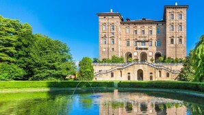 A large, historic building with a central courtyard and a reflecting pool. - 3T Boutique Hotel (Ivrea)