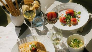 A table with various dishes, glasses of wine, and cutlery.