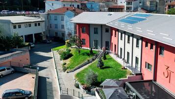 A courtyard with a red building, a tower, and a parking area.
