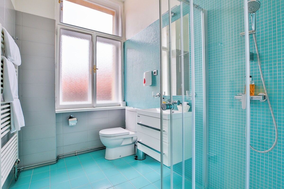 A bathroom with a toilet, sink, and shower.