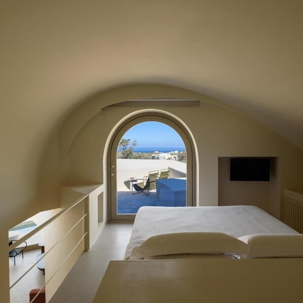 Une chambre avec vue sur la mer, un lit, un bureau et une chaise.