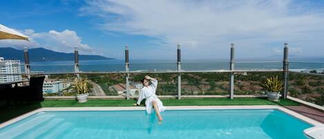 Una piscina al aire libre, sillones reclinables de piscina